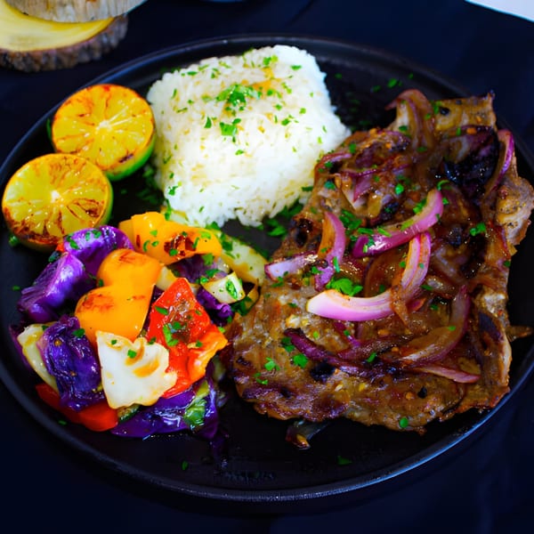 Grilled steak with red onions, white rice, colorful vegetables, and charred lime halves on a black plate.